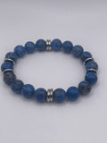 Blue beaded bracelet with silver accents on a white background