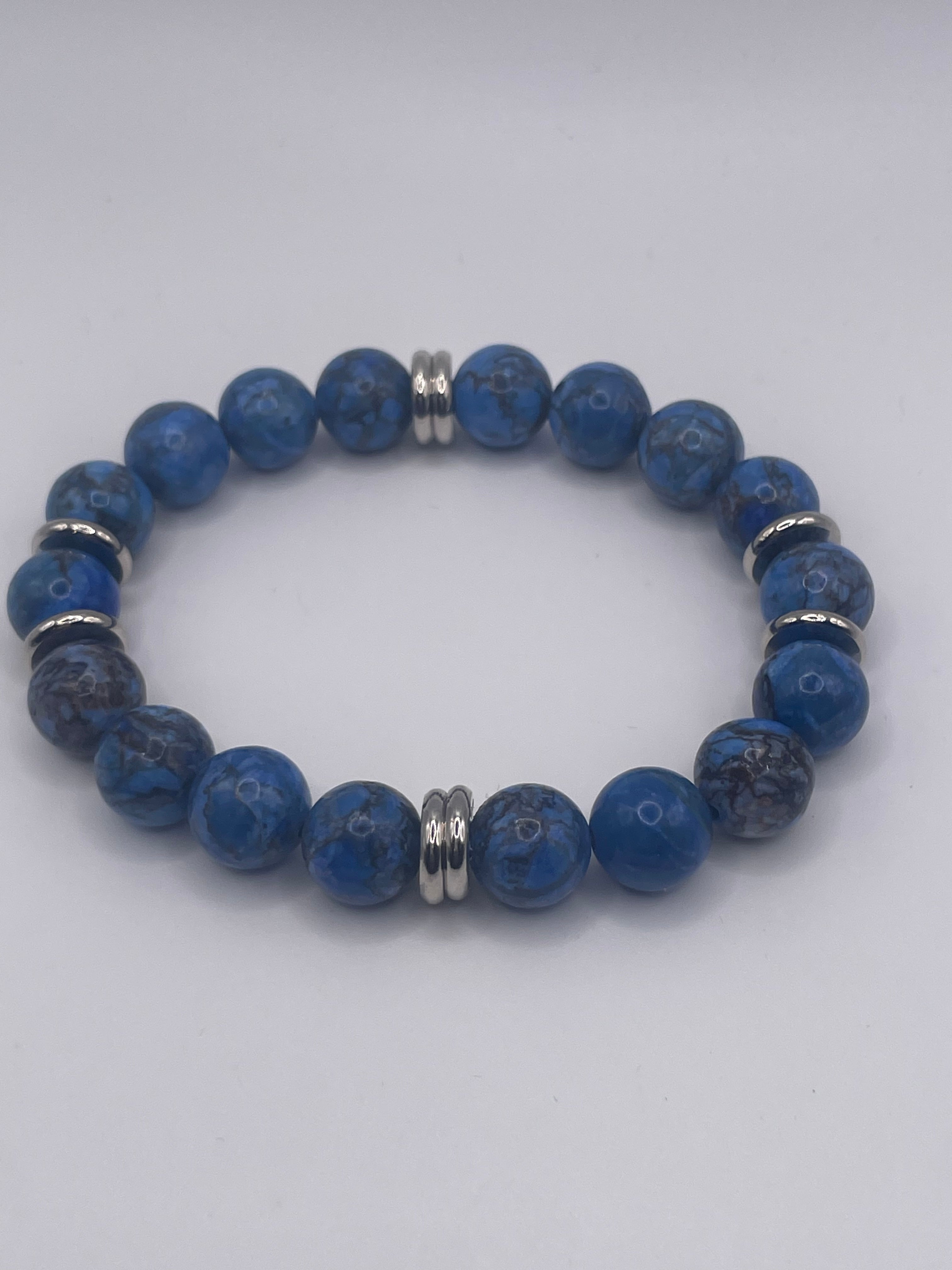 Blue beaded bracelet with silver accents on a white background
