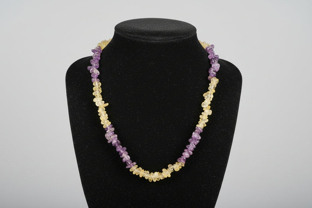 Black face mask with yellow and purple beads on a wooden surface