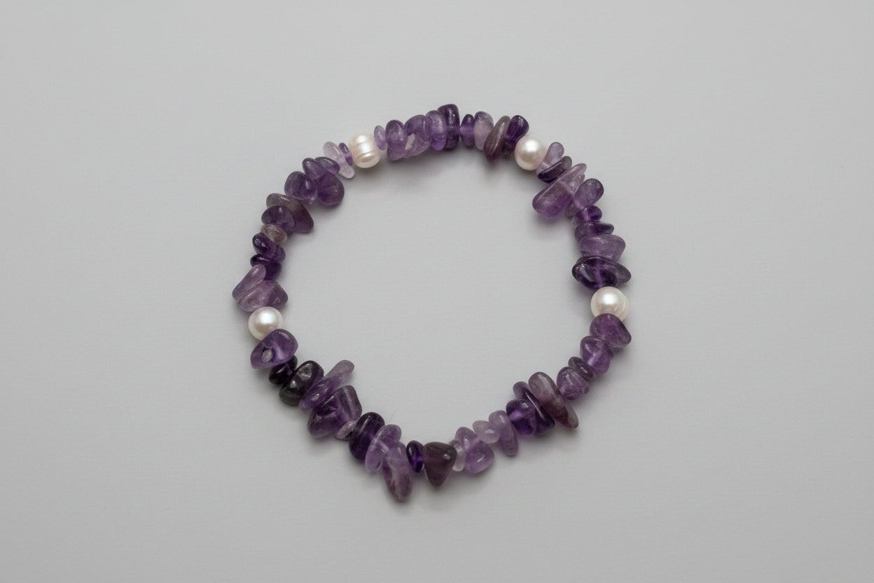 Amethyst and pearl bracelet on a wooden surface