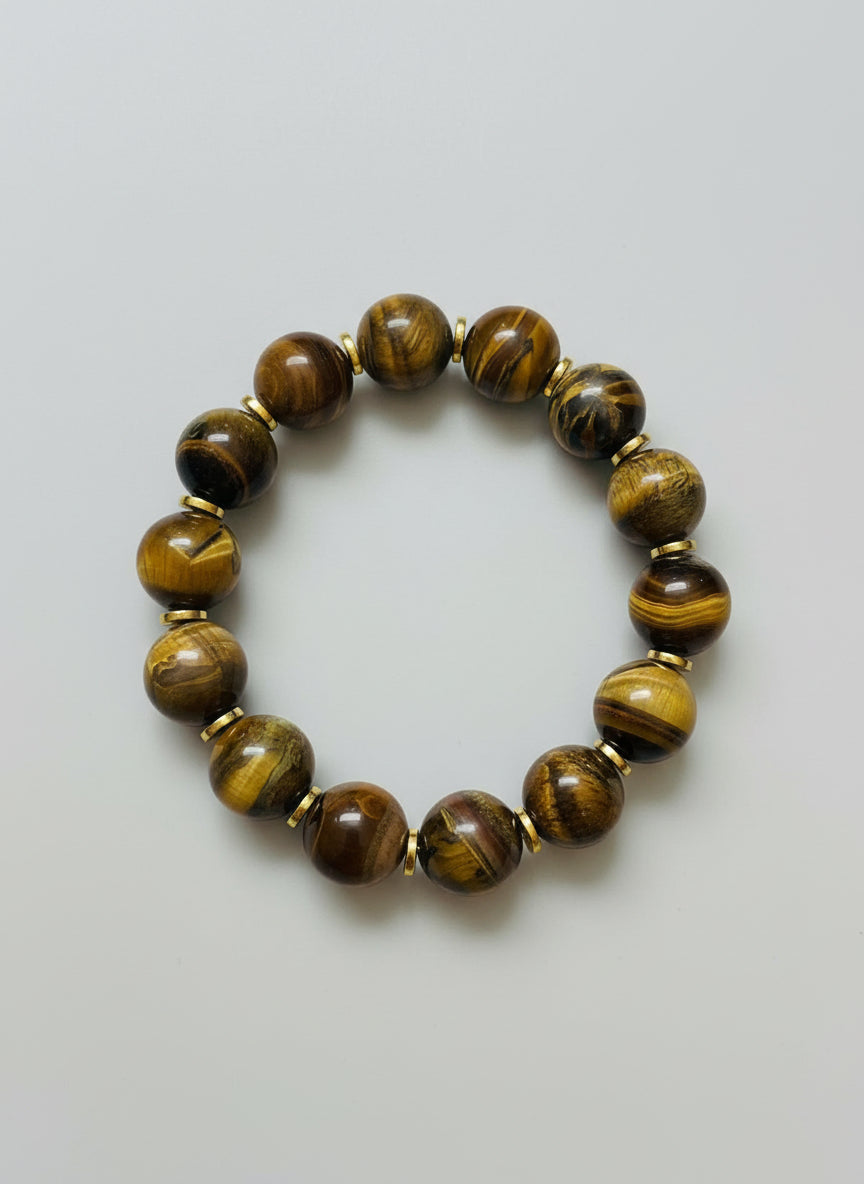 Beaded bracelet with tiger eye stones and gold spacers on a wooden surface