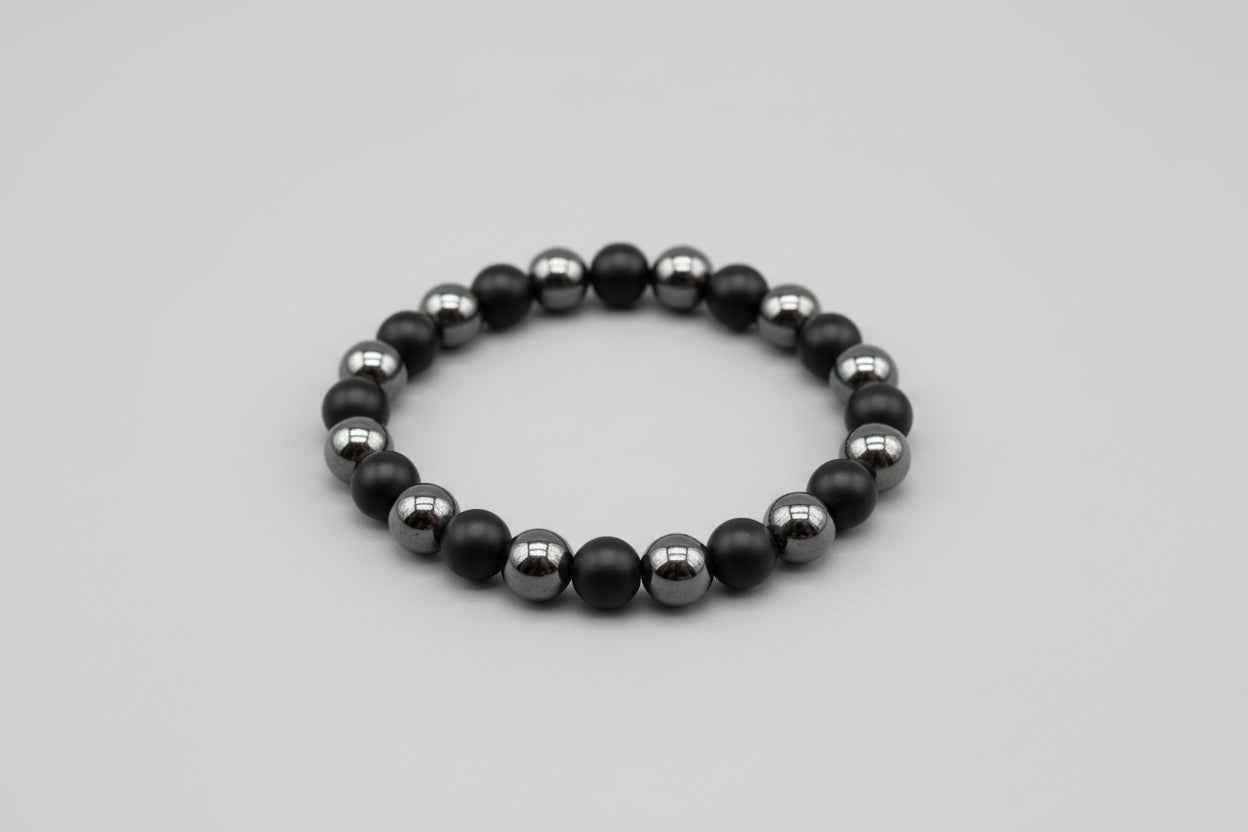 Black beaded bracelet on a gray background