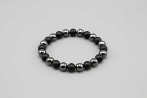 Black beaded bracelet on a gray background