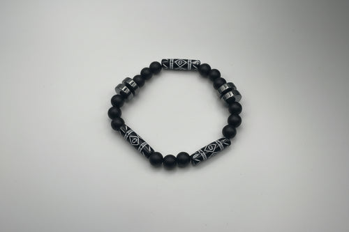 Black beaded bracelet with patterned metal accents on a white background