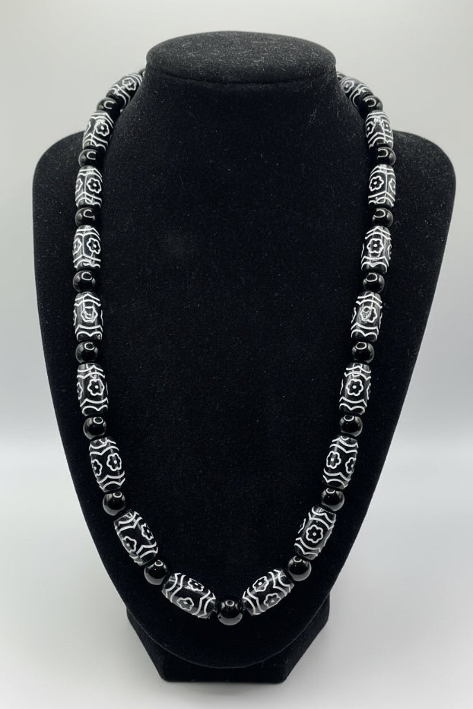 Black headband with decorative silver band on a white background