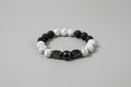 Bracelet with black, white, and gray beads on a wooden surface
