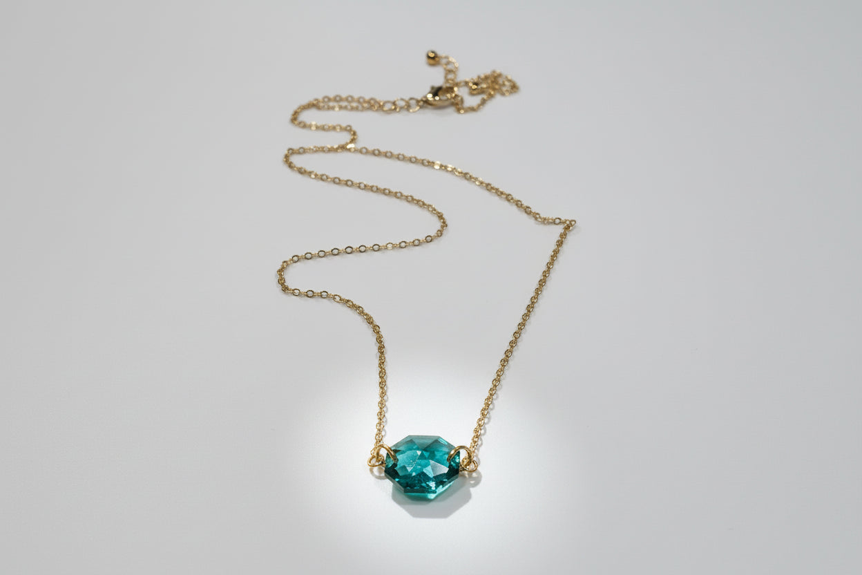 Necklace with a blue pendant on a white plate