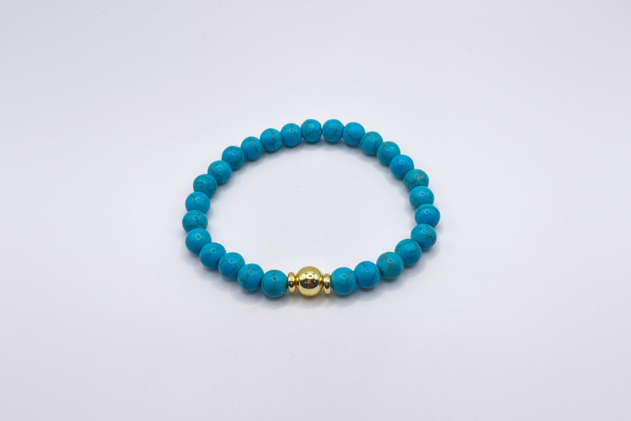 Blue beaded bracelet with a gold clasp on a white background