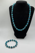 Blue Jasper beaded bracelet on a black stand with another bracelet on a white surface.