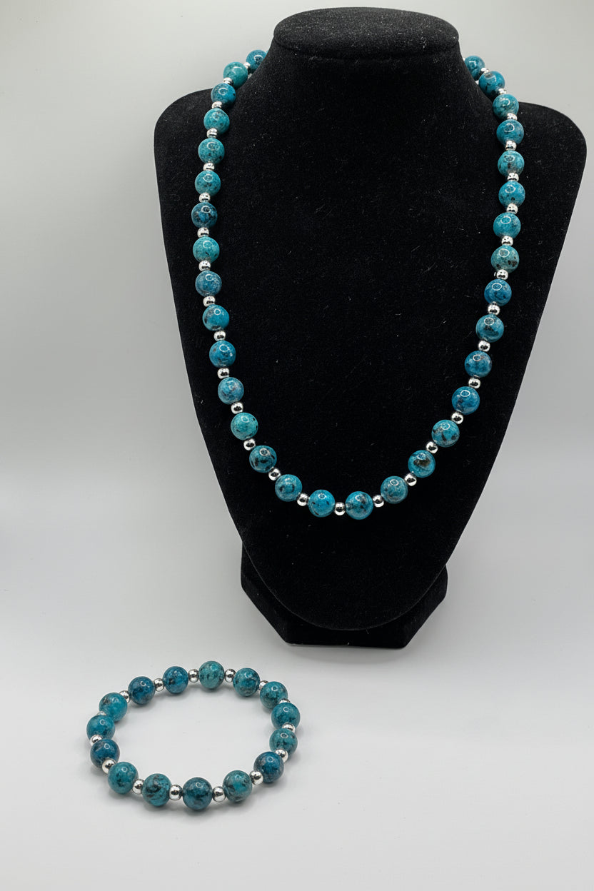 Blue Jasper beaded bracelet on a black stand with another bracelet on a white surface.