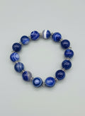 Blue beaded bracelet on a textured gray background