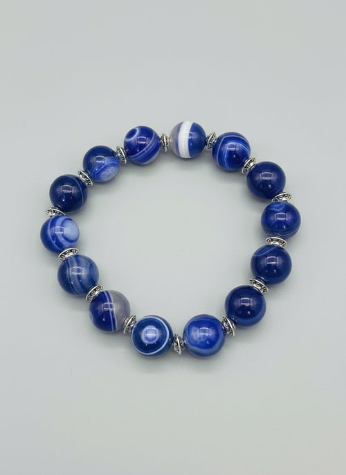 Blue beaded bracelet on a textured gray background