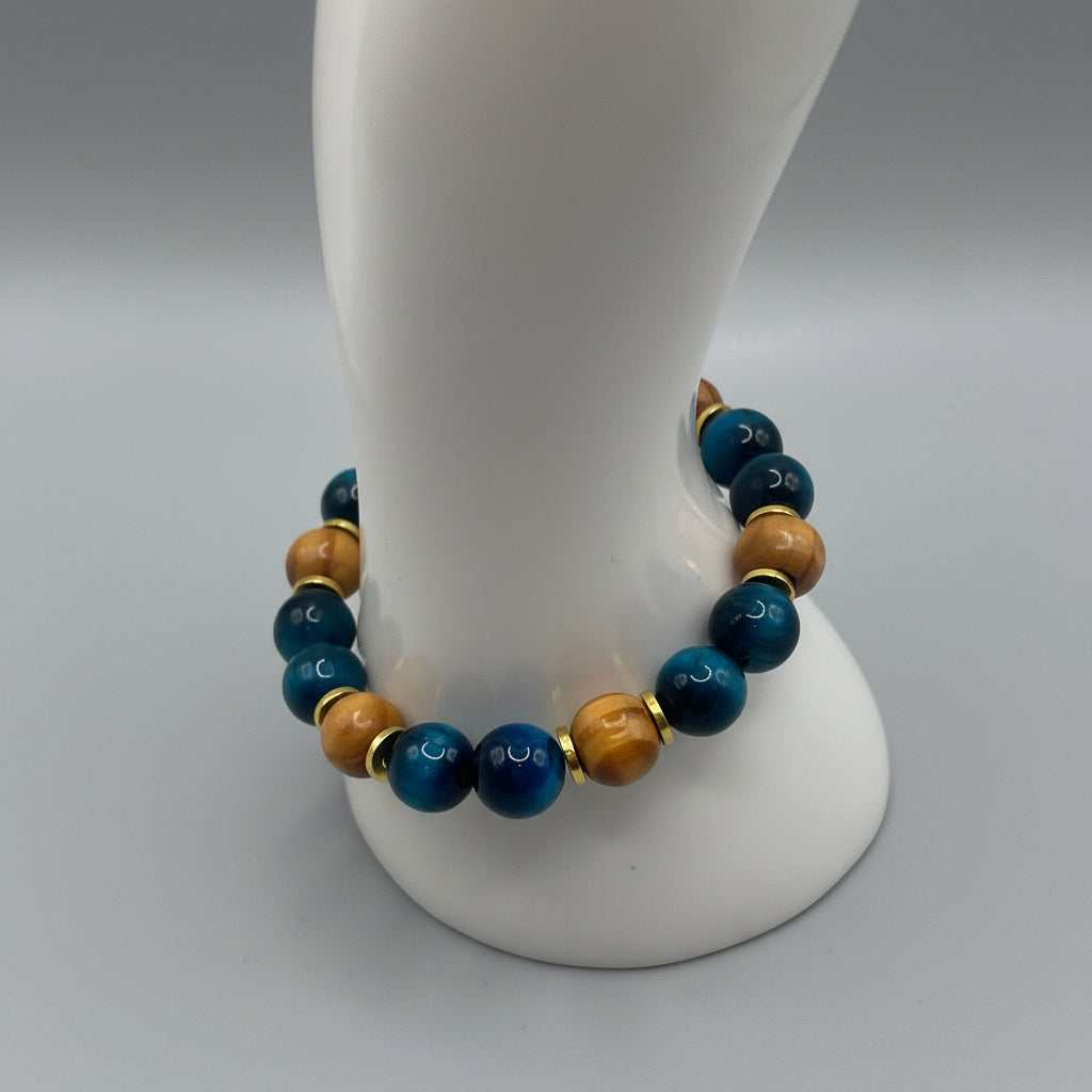 A beaded stretch bracelet displayed on a white mannequin arm. The bracelet features alternating dark blue and brown beads separated by small gold spacer rings.