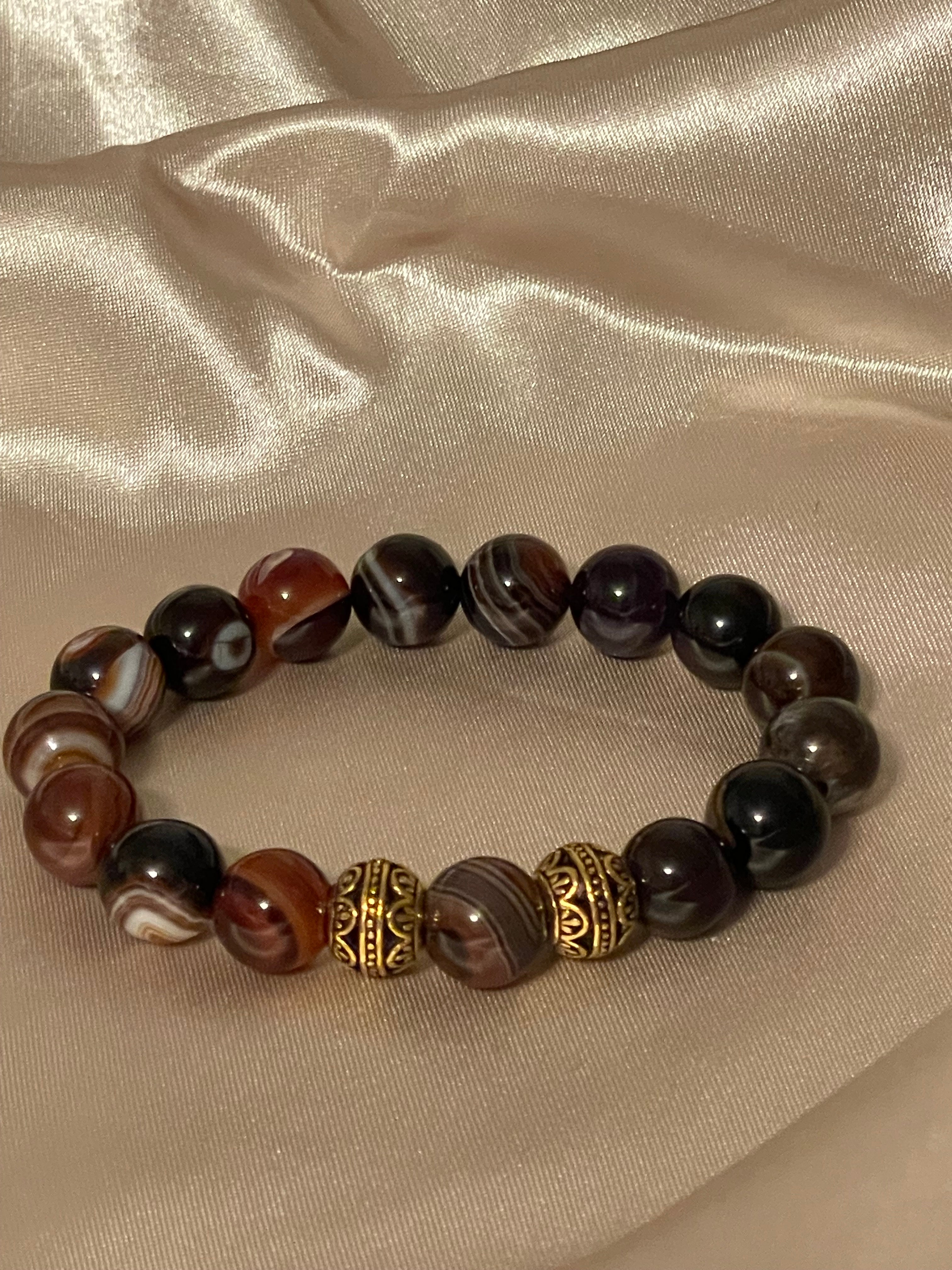 Beaded bracelet with a gold accent on a beige fabric background