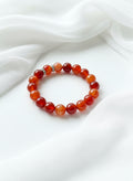 Beaded bracelet with red and silver spacers beads on a wooden surface