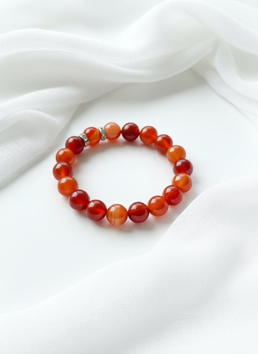 Beaded bracelet with red and silver spacers beads on a wooden surface