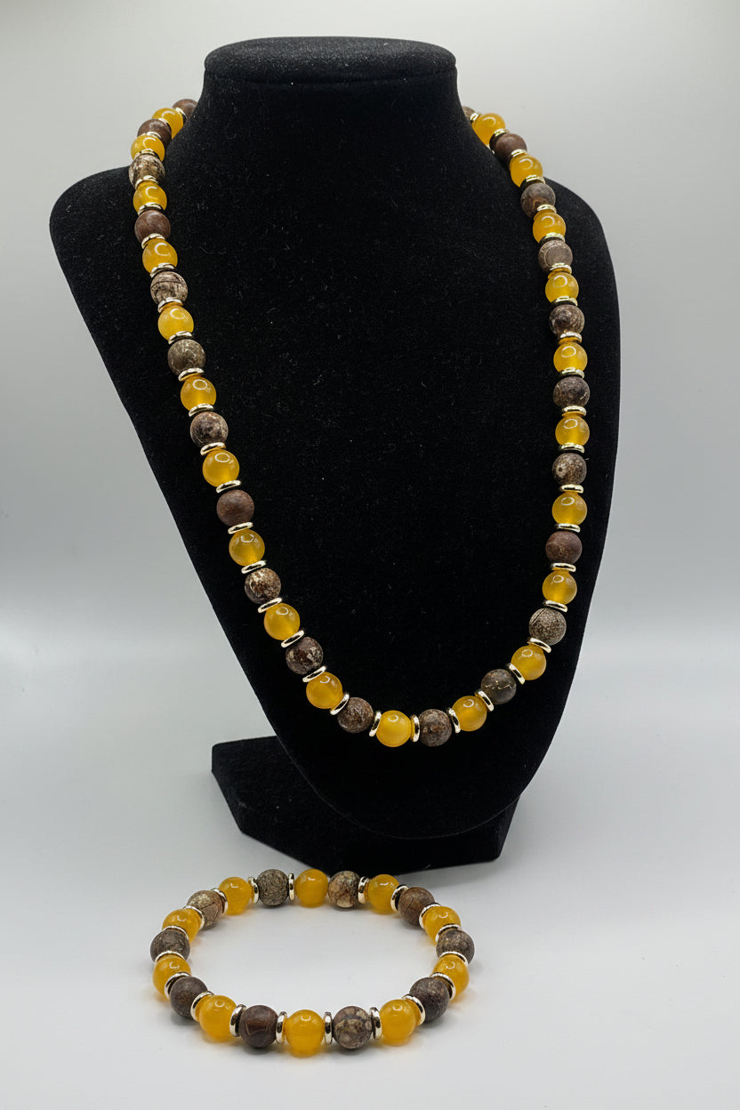 Beaded bracelet with yellow and brown beads on a black stand against a white background