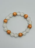Beaded bracelet with alternating white and brown beads on a dark textured background