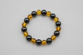 Bracelet with black and yellow beads on a wooden surface