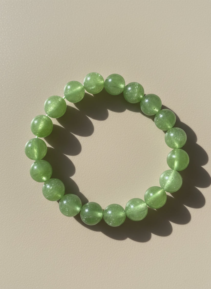 Green beaded bracelet on a beige background