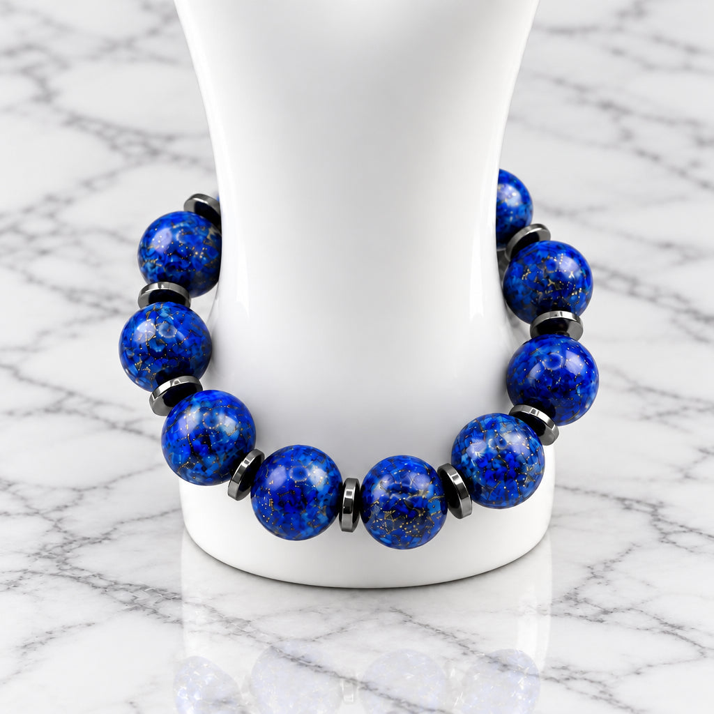 A beaded stretch bracelet made of deep blue lapis lazuli stones separated by small black spacer beads, displayed on a white mannequin stand against a light gray background.
