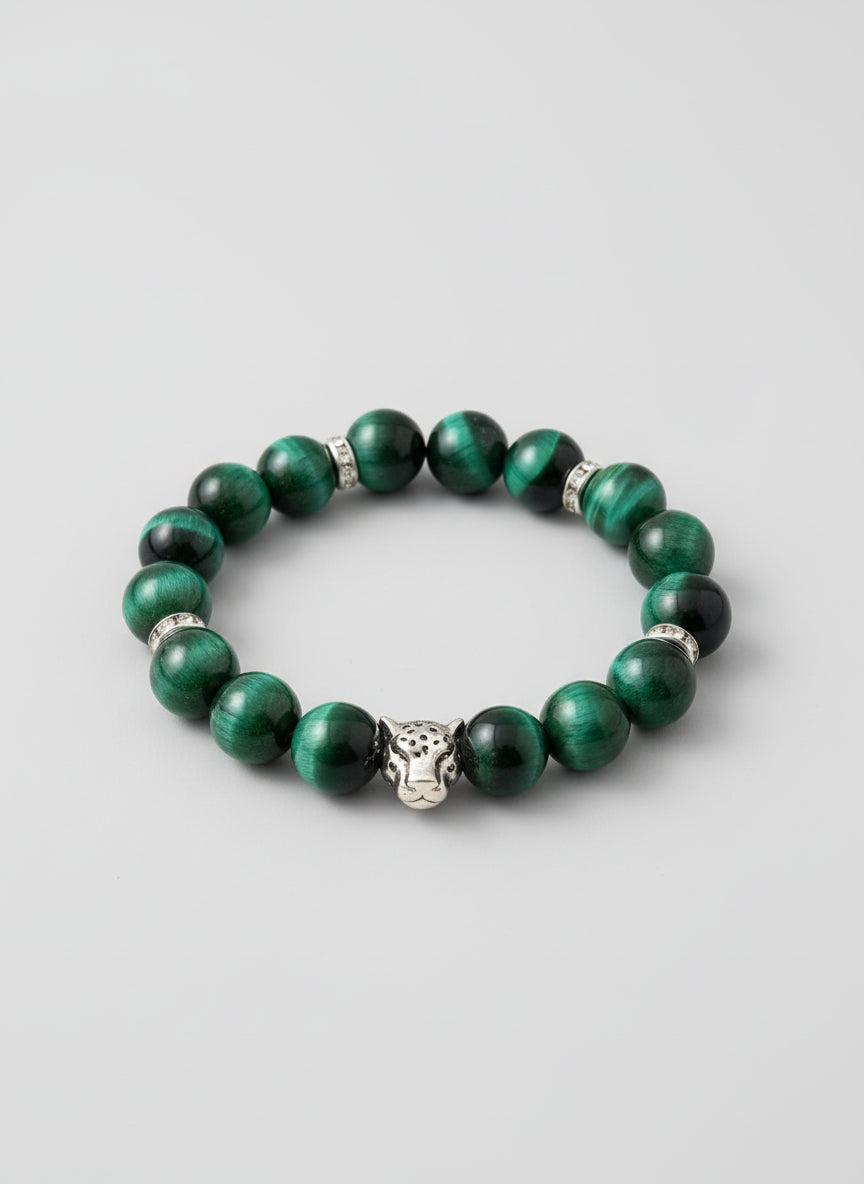 Green beaded bracelet with a silver charm on a wooden surface