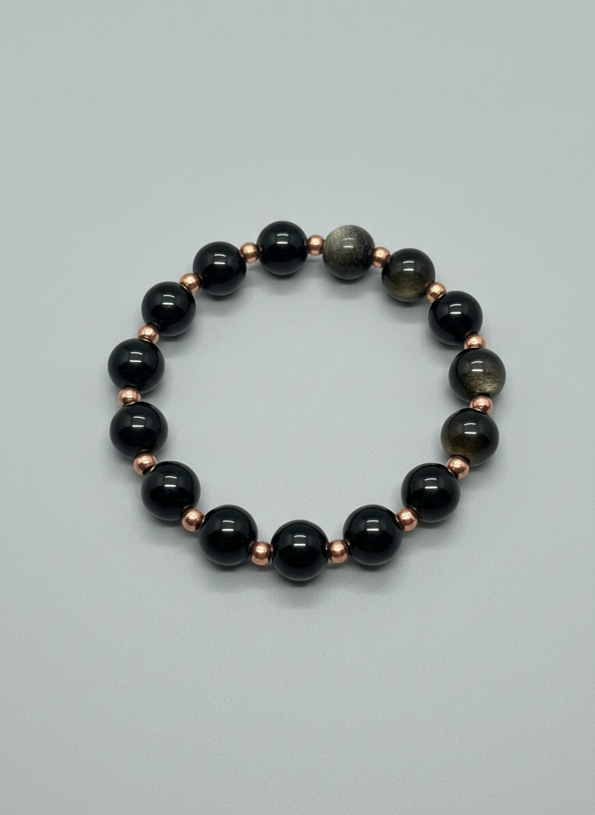 Black and rose gold beaded bracelet on a wooden surface
