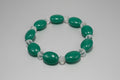 Green beaded bracelet with clear crystals on a light gray background