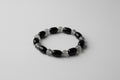 Black and gray beaded bracelet on a white surface