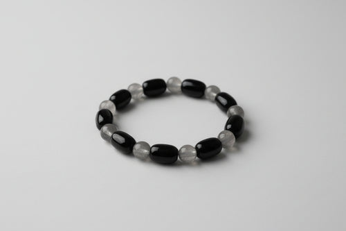 Black and gray beaded bracelet on a white surface
