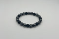 Black beaded bracelet on a light gray background