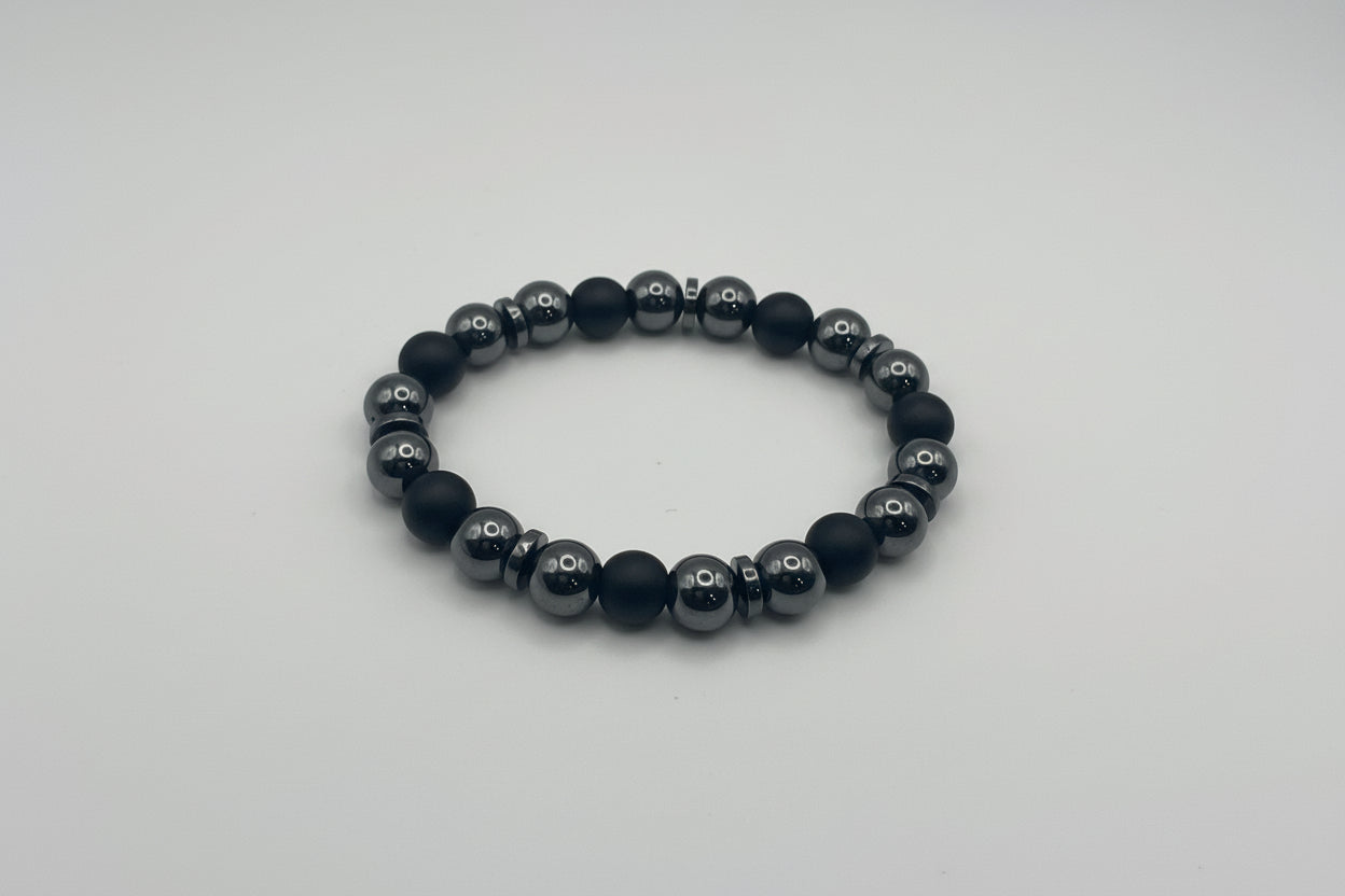 Black beaded bracelet on a light gray background