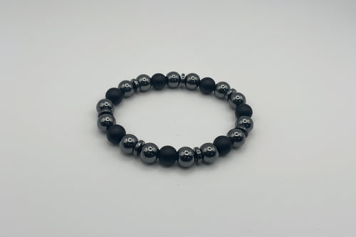 Black beaded bracelet on a light gray background