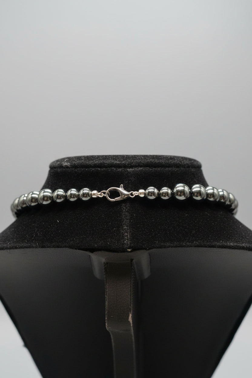natural black beaded bracelet with a lobster clasp, displayed on a black velvet jewelry bust.