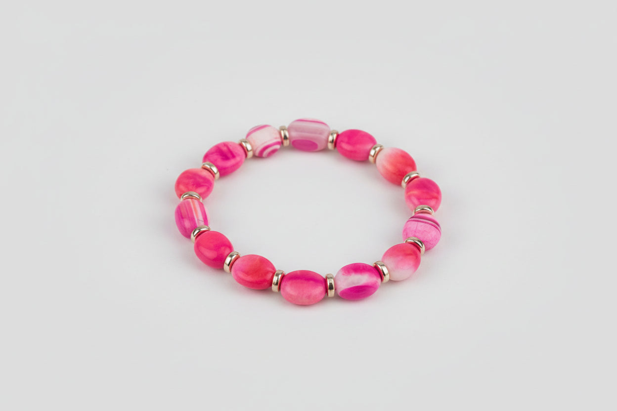 Pink beaded bracelet on a wooden surface