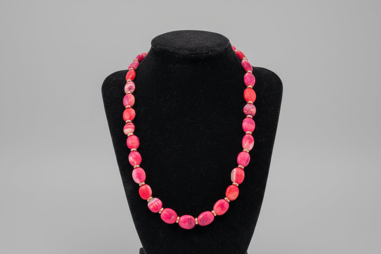 Pink beaded necklace on a black stand