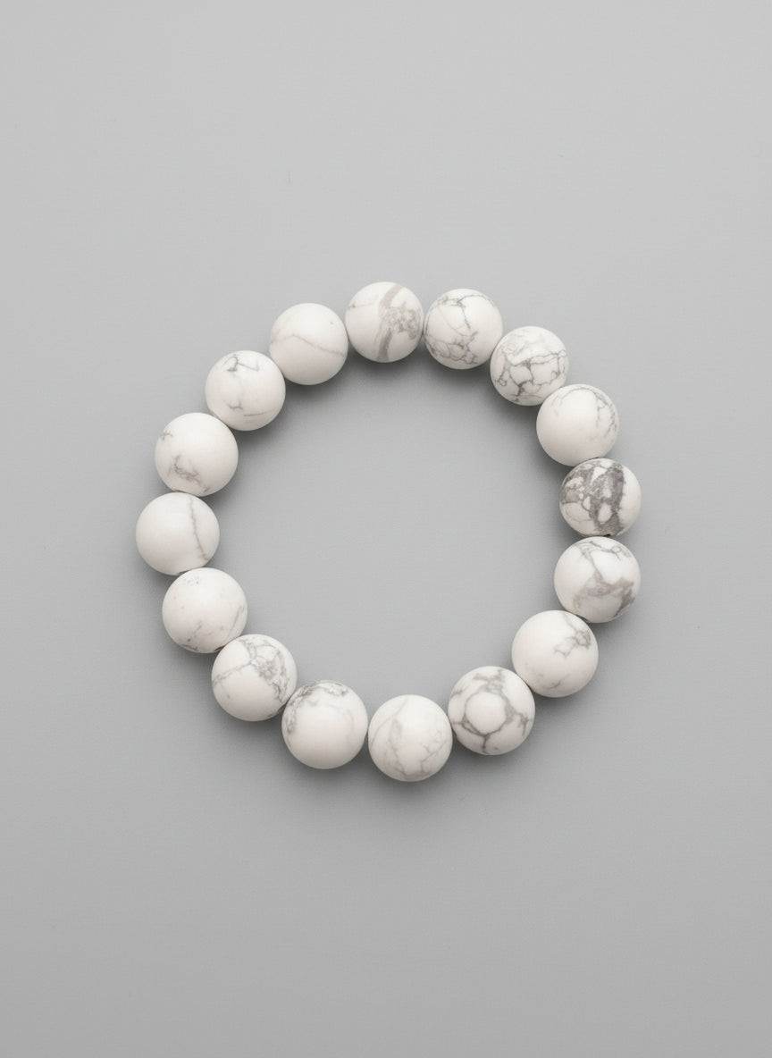 White marbled beaded bracelet on a textured black background