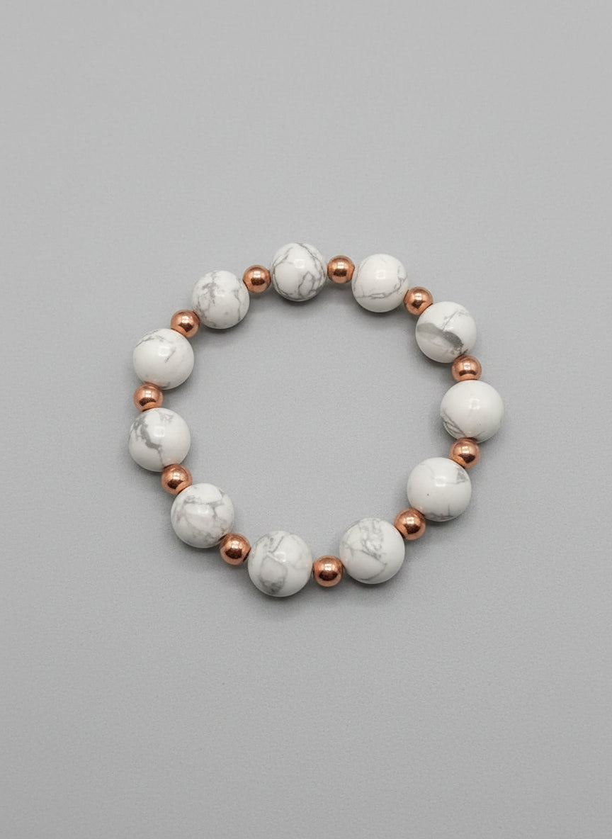 Bracelet with white beads and a tag on a dark textured surface