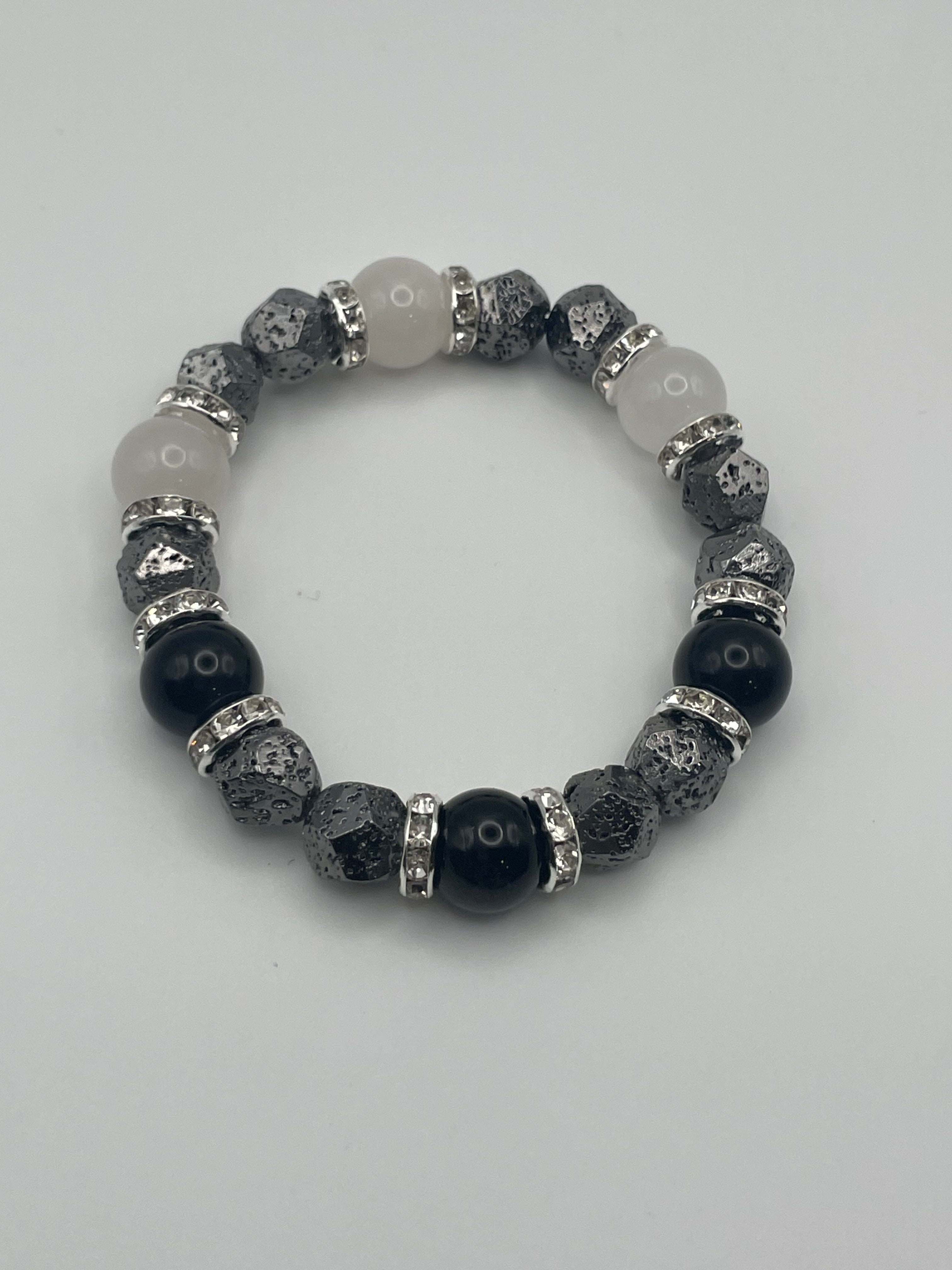 Beaded bracelet with black, gray, and white beads on a light gray background