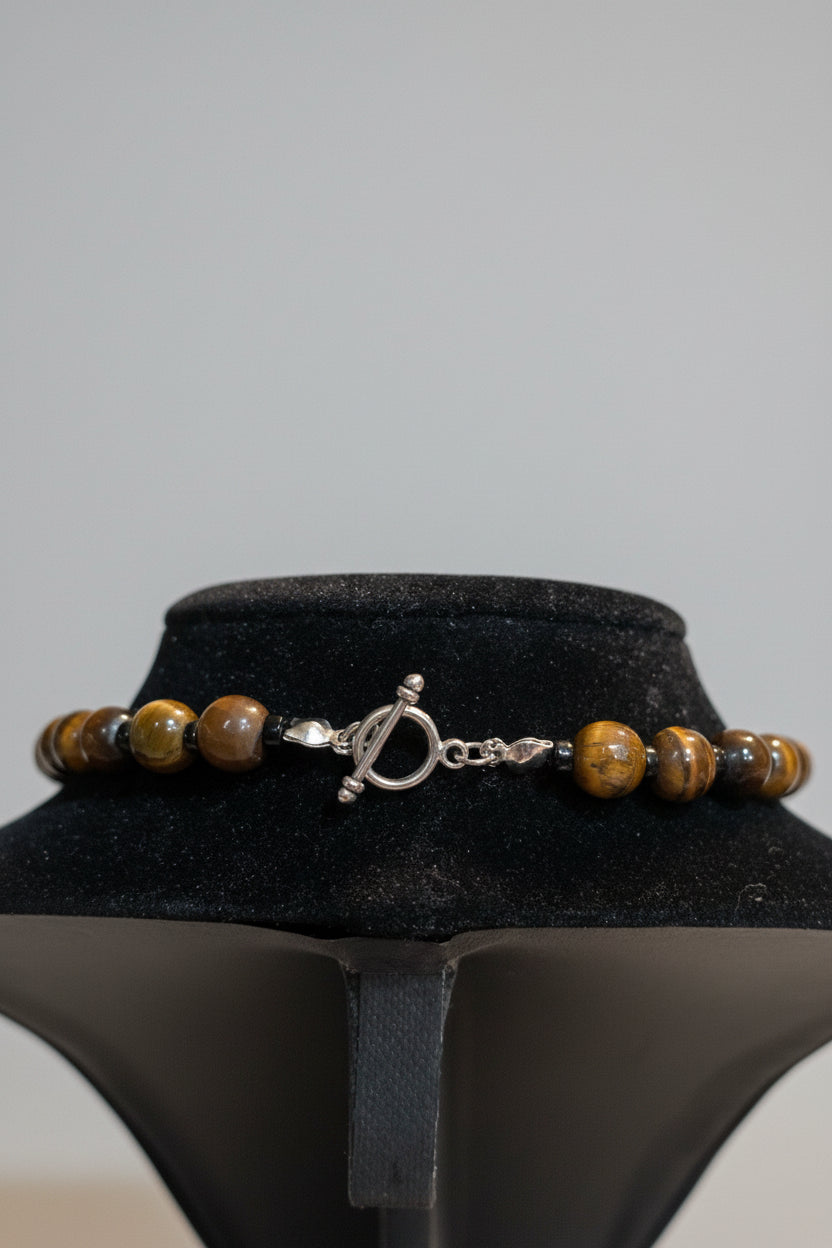 Beaded necklace with a silver clasp on a black stand
