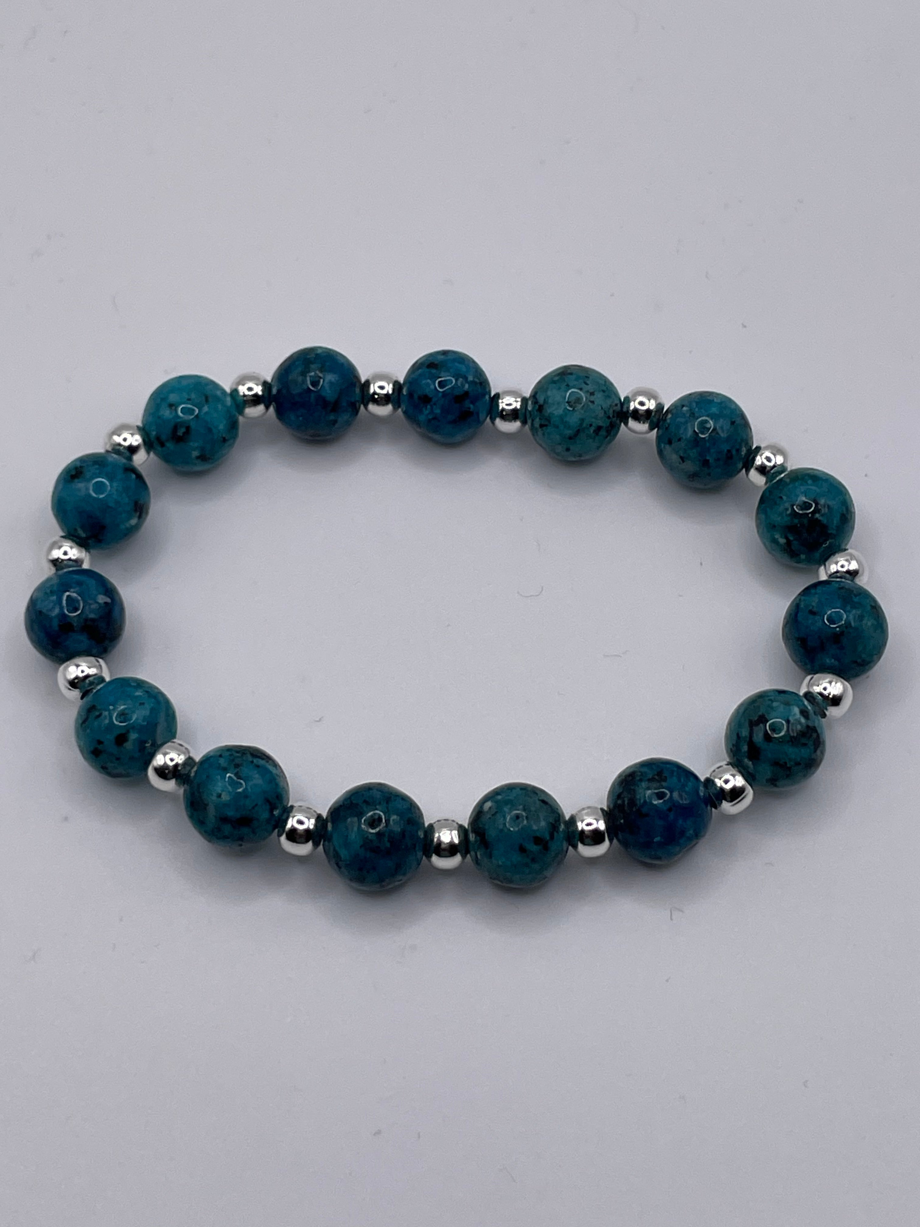 Blue beaded bracelet with silver accents on a gray background