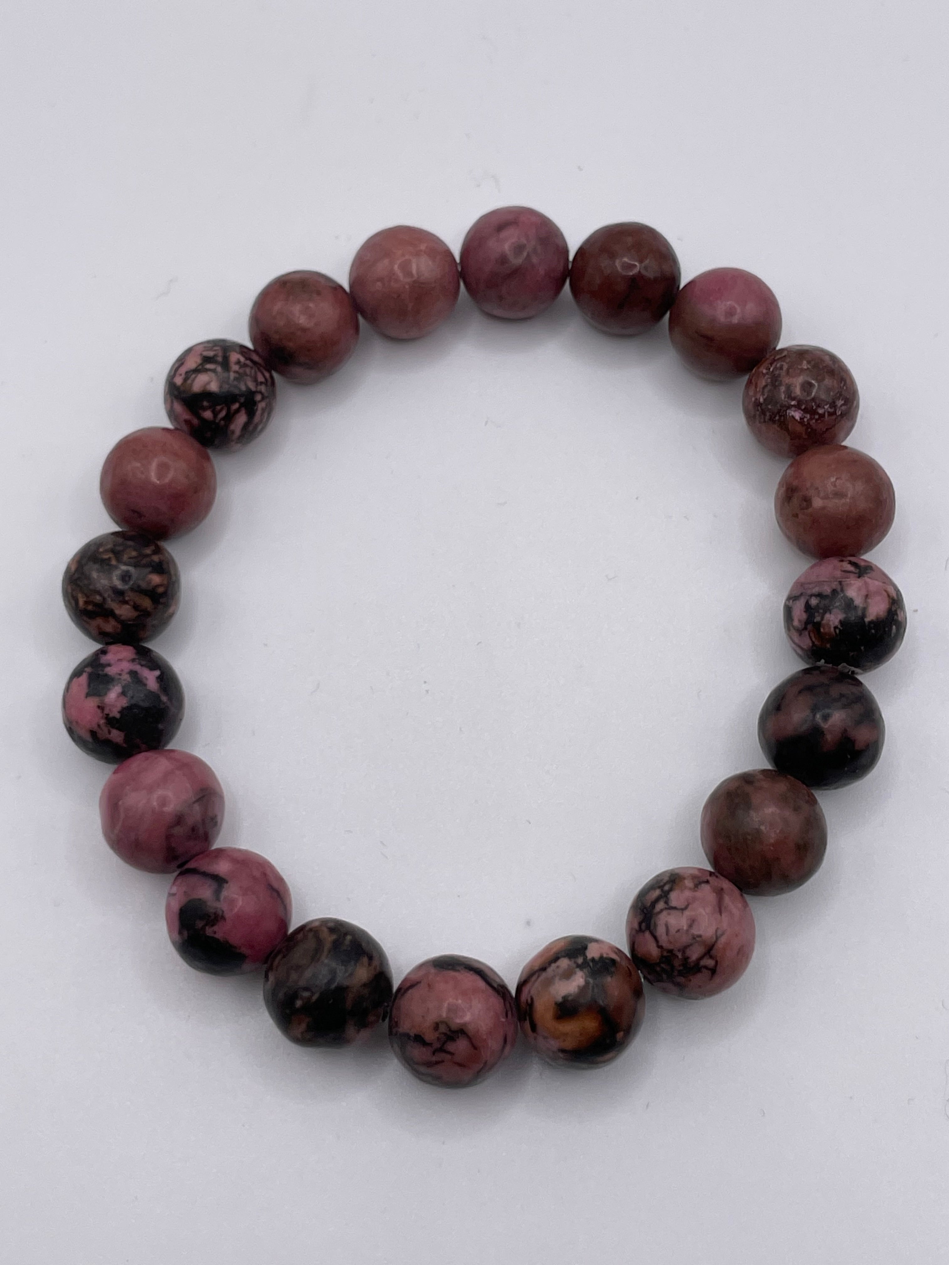 Round beaded bracelet with purple and black stones on a white background