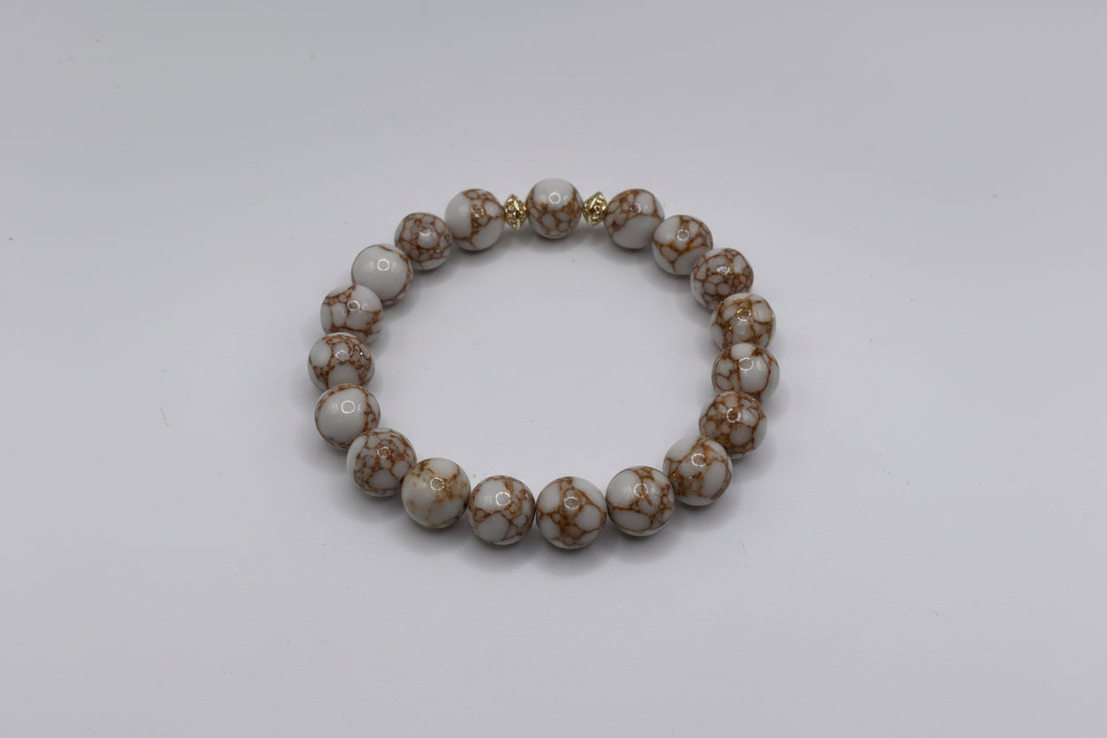 Beaded bracelet with gold accents on a white background