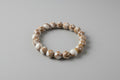 Beaded bracelet with gold accents on a white surface