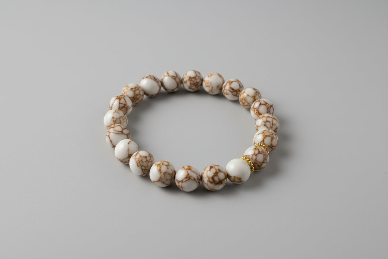 Beaded bracelet with gold accents on a white surface