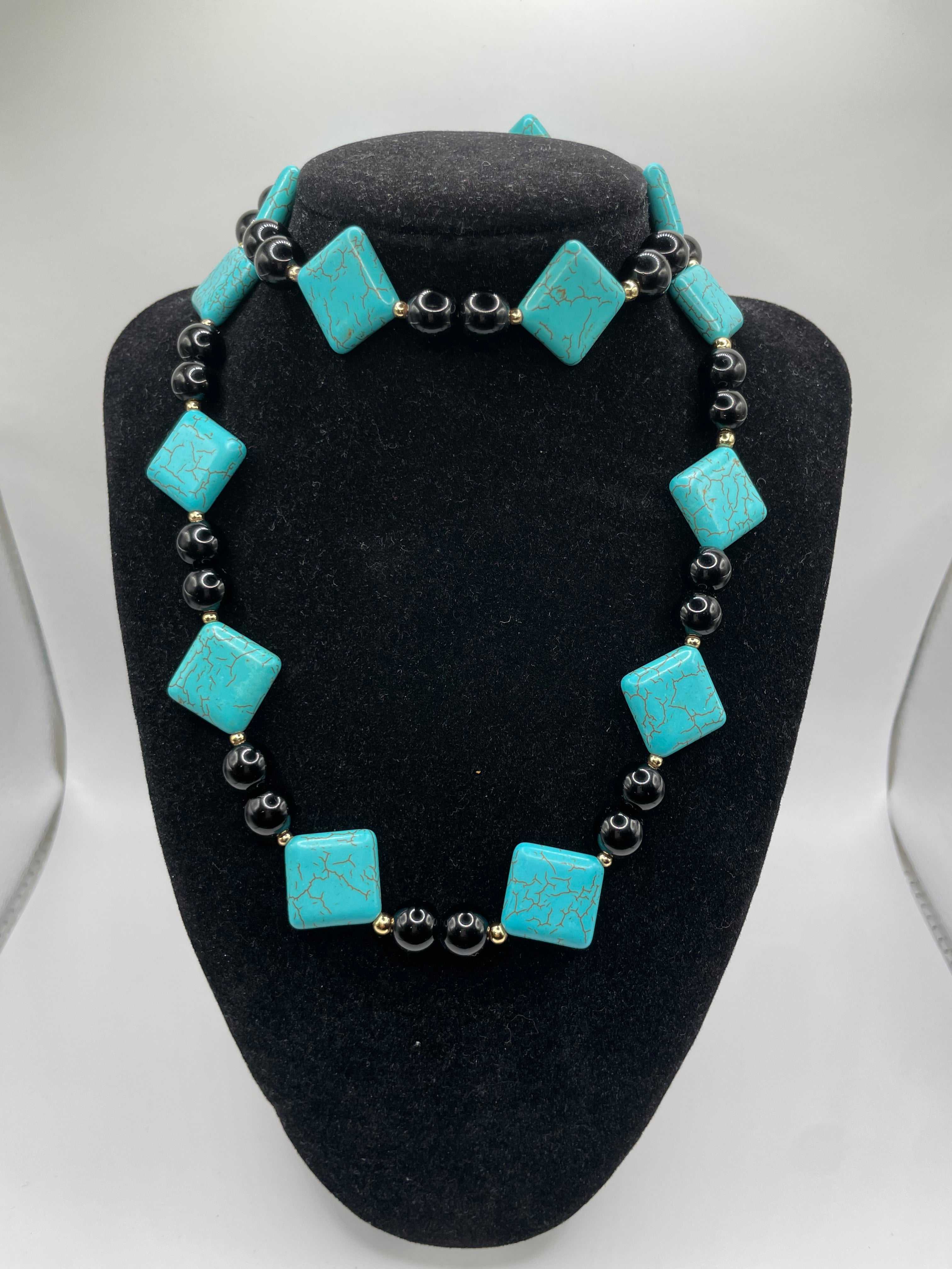 Turquoise square beads on a black stand