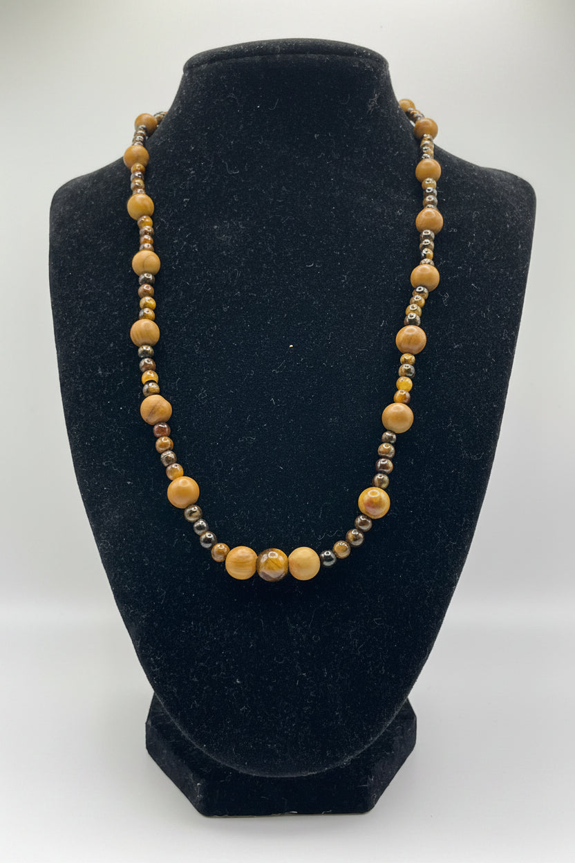 Necklace with wooden beads on a black velvet stand against a white background