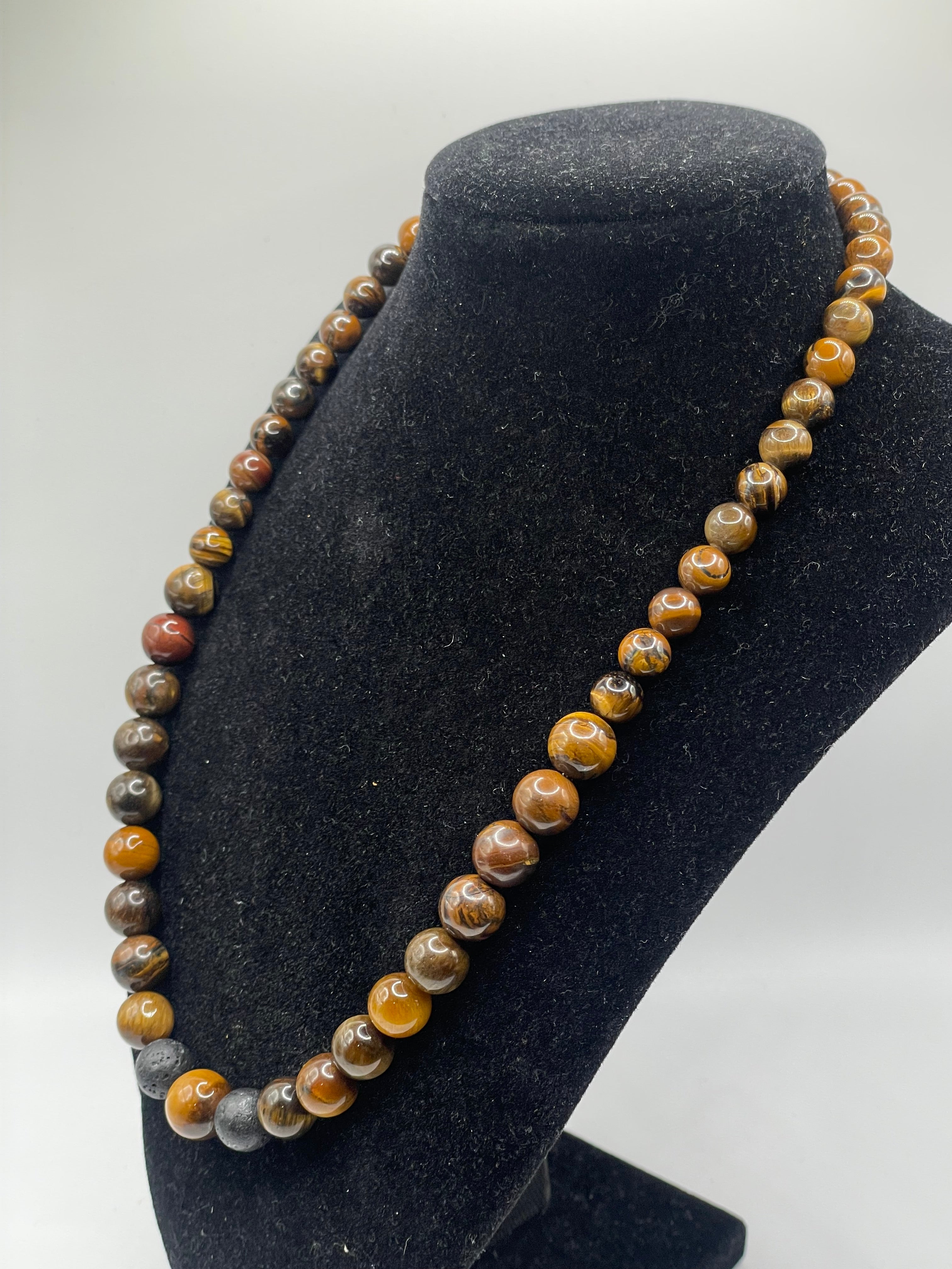 Beaded necklace on a black stand with a white background