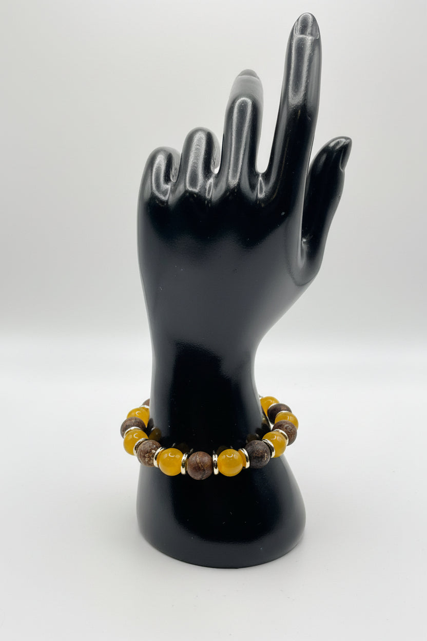 Bracelet with yellow and brown beads on a black stand