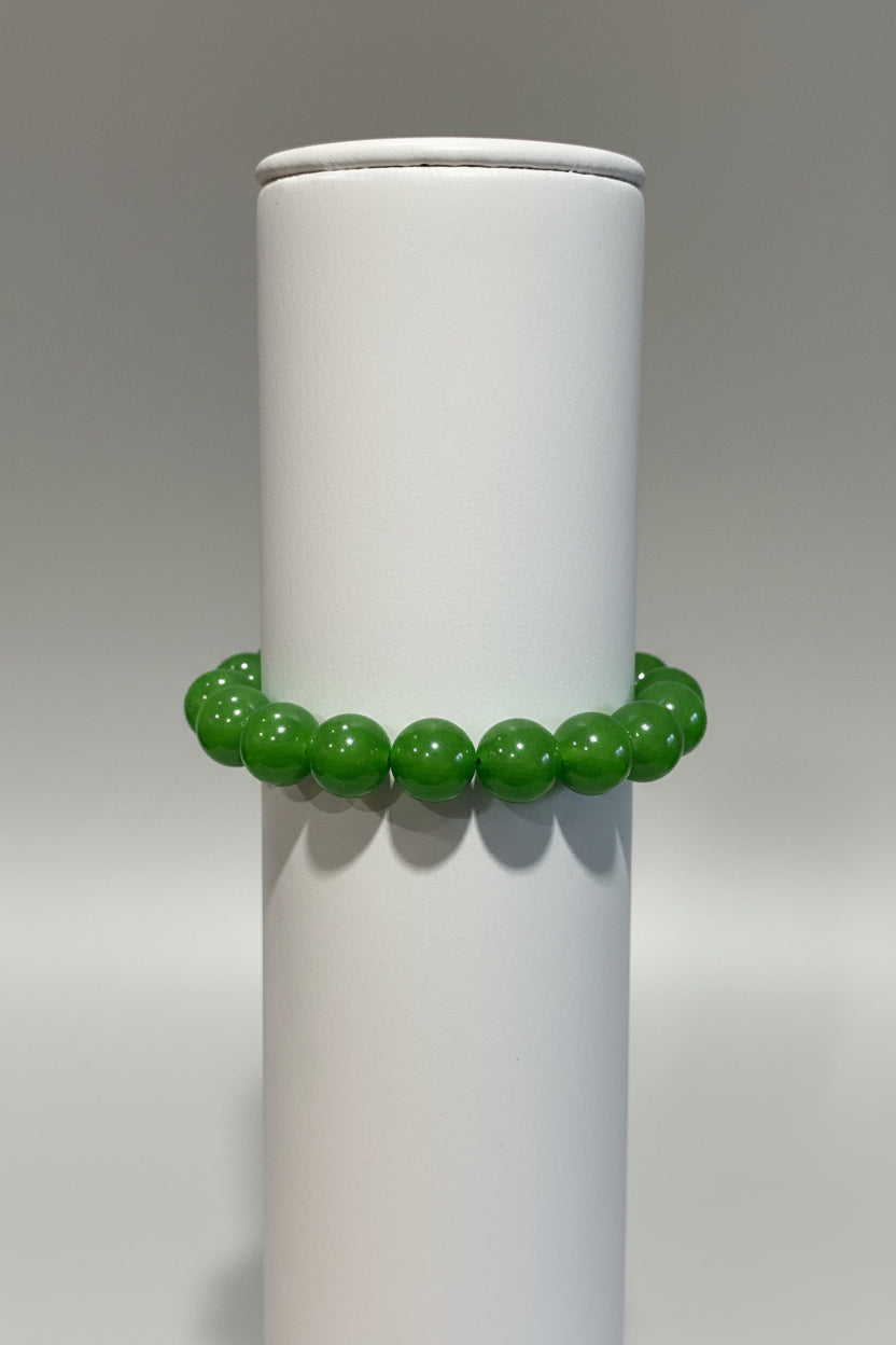 Green beaded bracelet on a metal surface